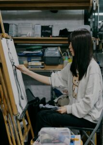 Young artist sketching a figure in a Shinjuku atelier, Tokyo. Creative and focused atmosphere.